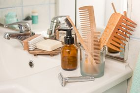 浴室柜台上的零废物产品包括竹梳、金属剃须刀、竹牙刷、肥皂等