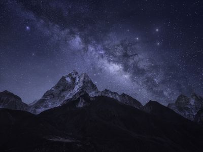 A wildly starry night sky over mountains