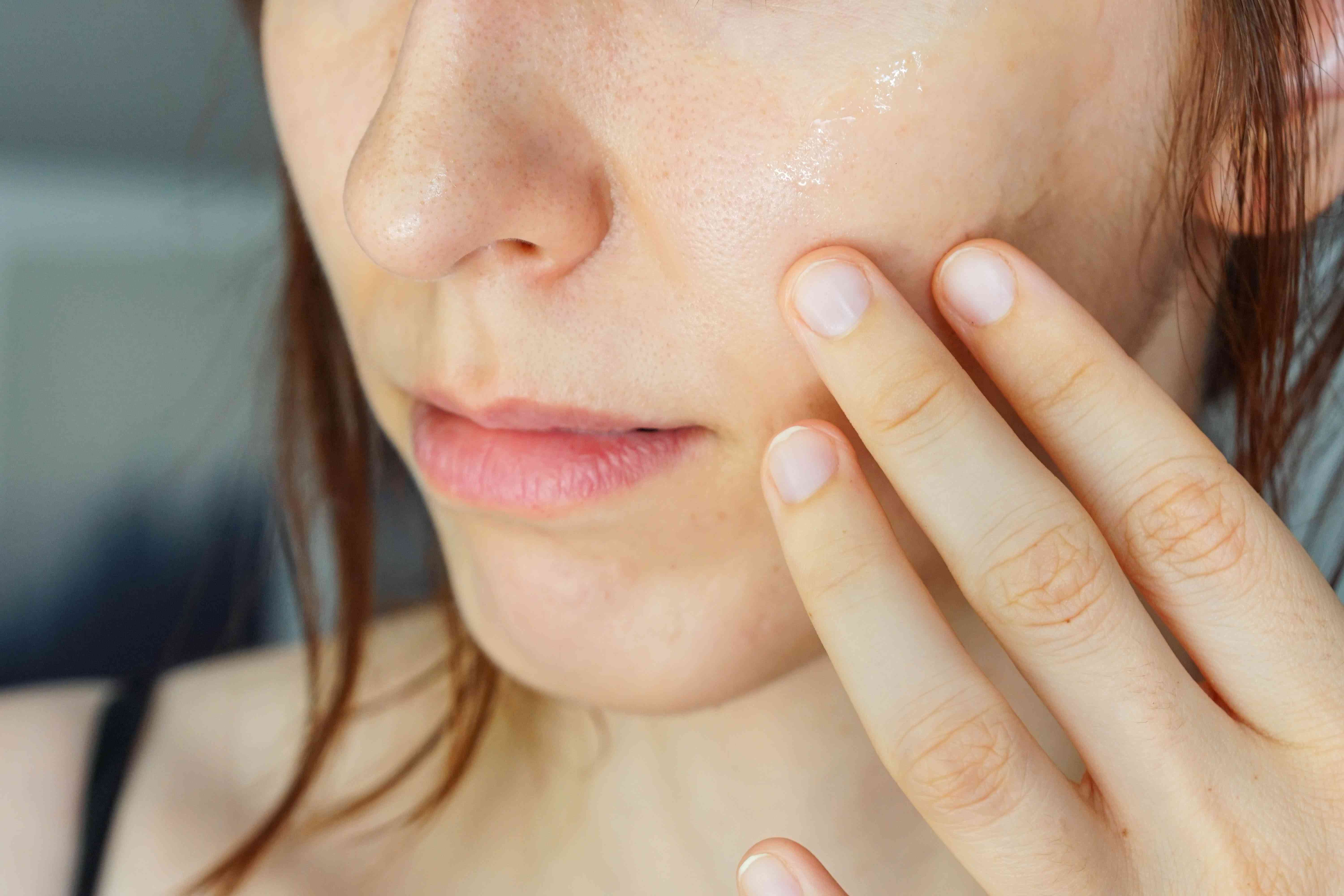 女性洗澡后直接在脸颊上涂油