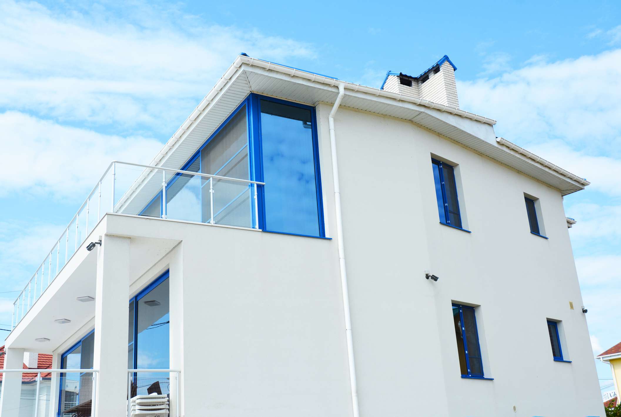 用玻璃阳台保护百叶窗的现代房屋。
