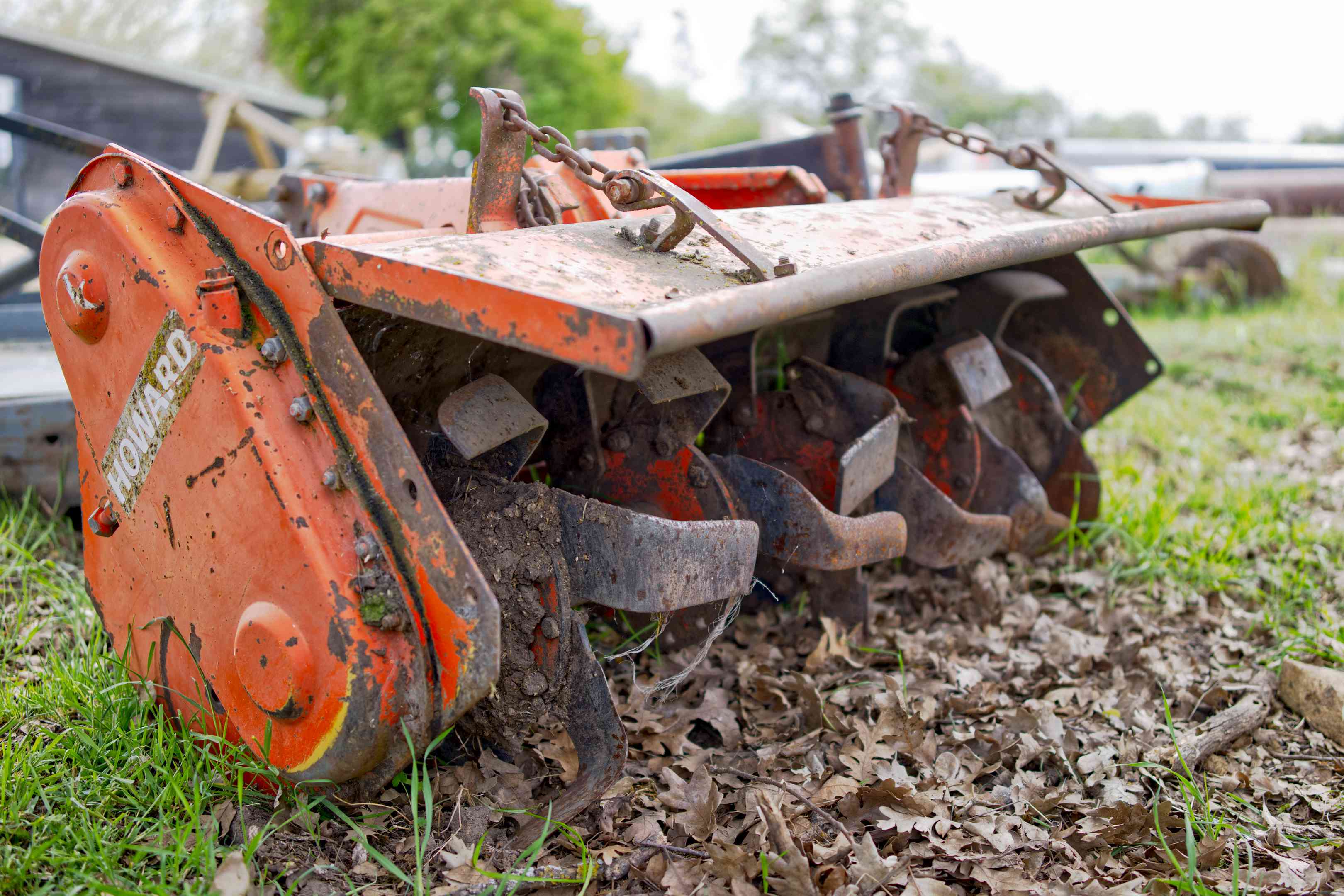 关闭橙色金属PTO TIRLER农场设备的低空射击破坏土壤