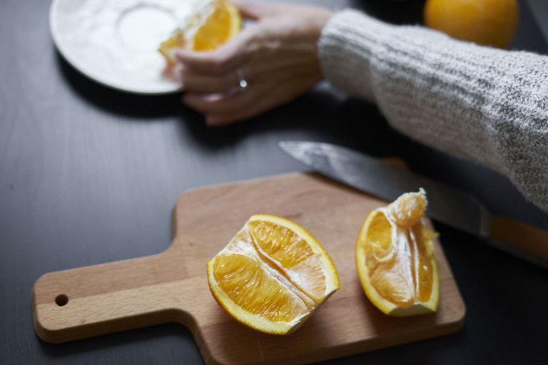 人们把橙子切成两半，放在砧板上冷冻