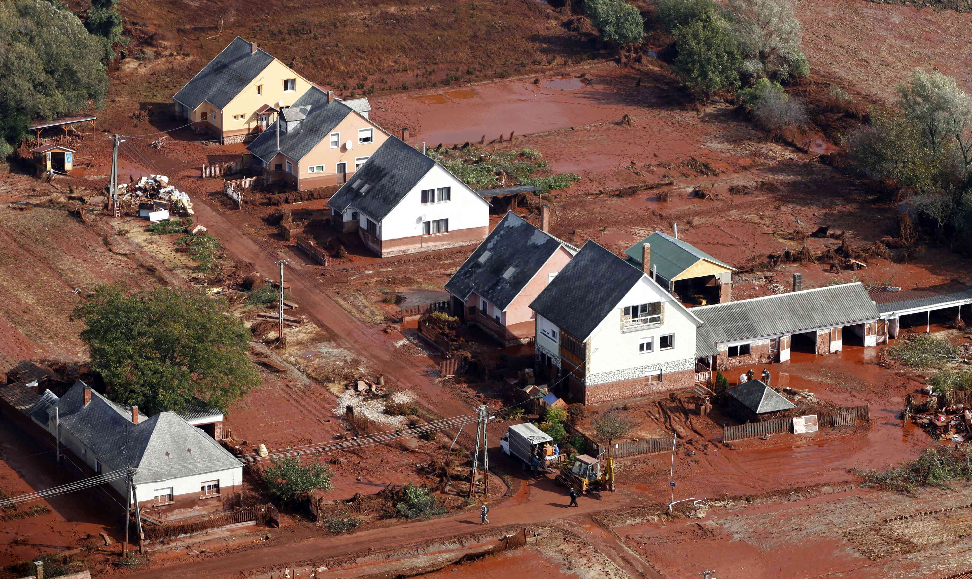 红色泥浆溢出，淹没了房屋＂width=