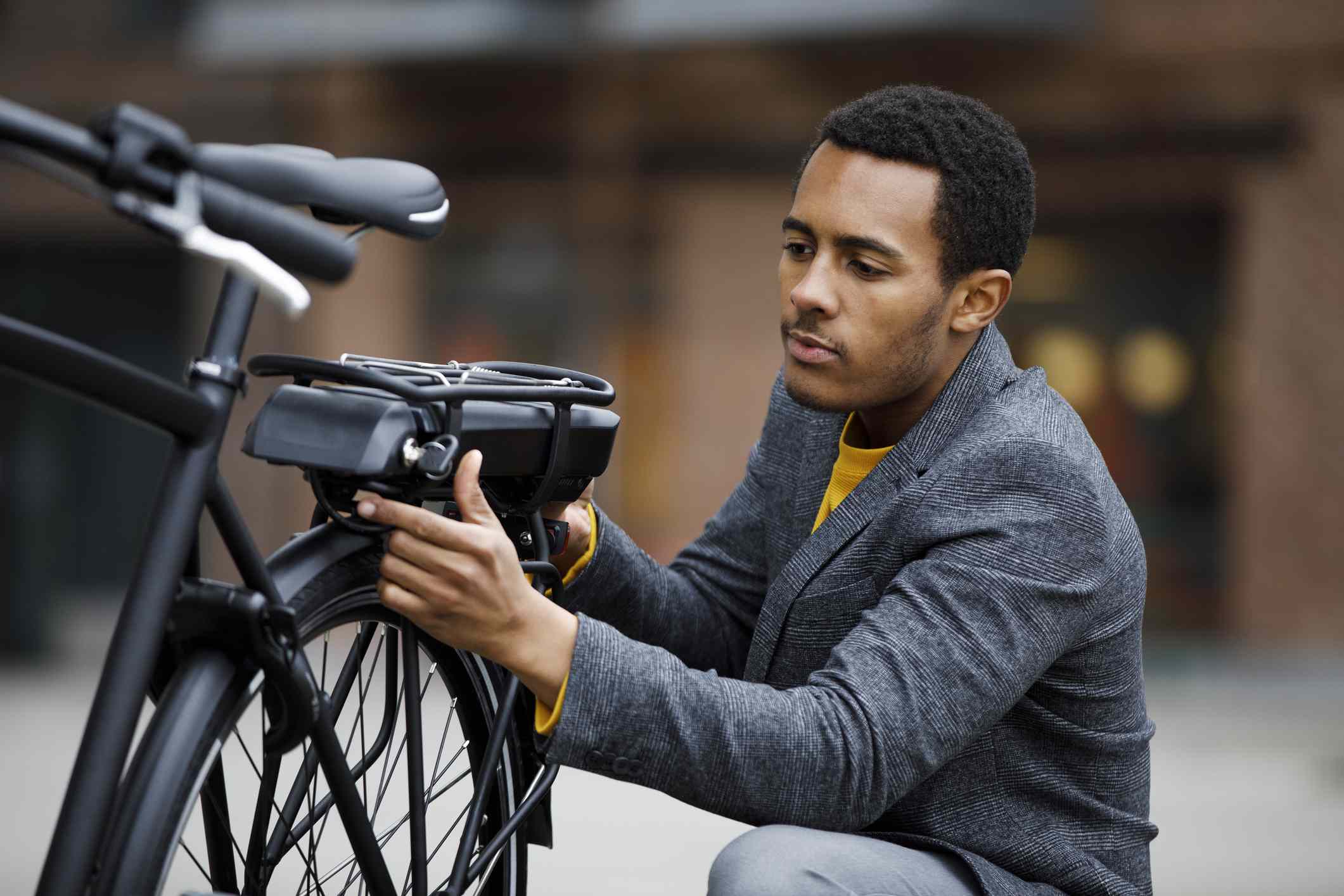 年轻人在电动自行车上更换电池组