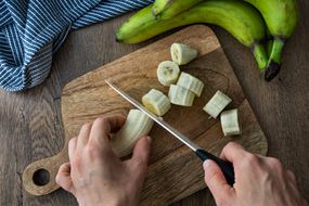手将绿色香蕉切成片，使烤箱干燥并作为片“width=