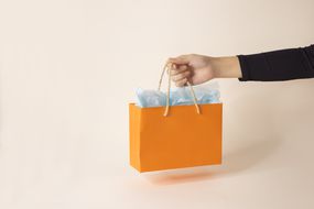 Holding an orange gift bag
