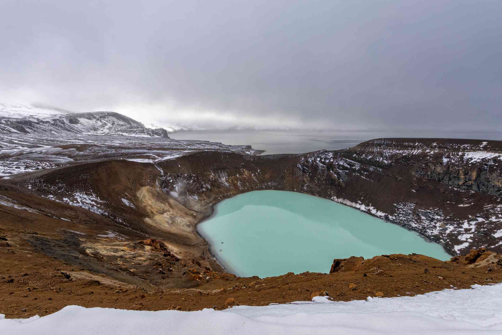 在阴天，火山口湖充满了浑浊的蓝水