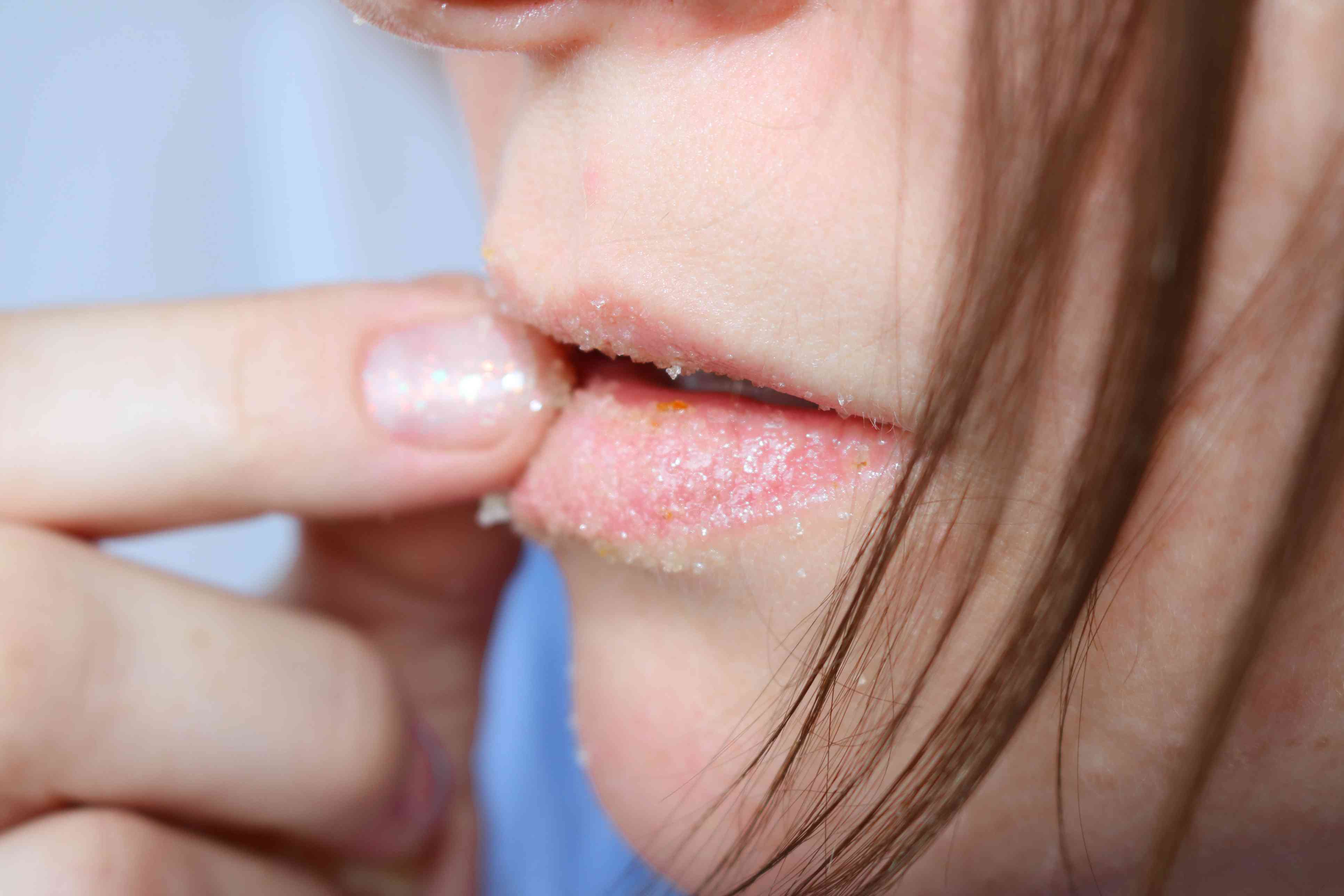 一个女人在她的嘴唇上摩擦糖。