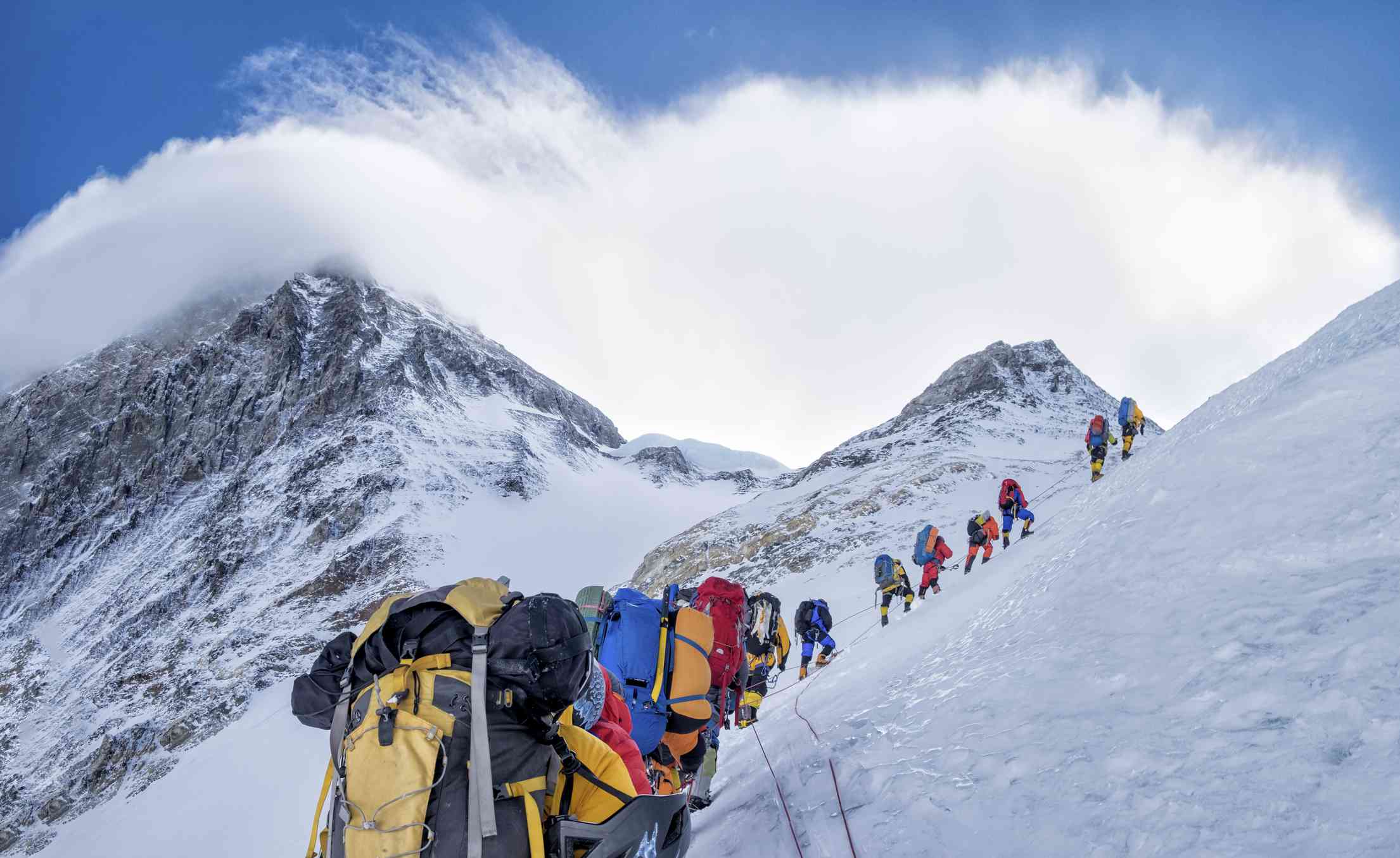 在珠穆朗玛峰上用绳子绑住的登山队＂width=