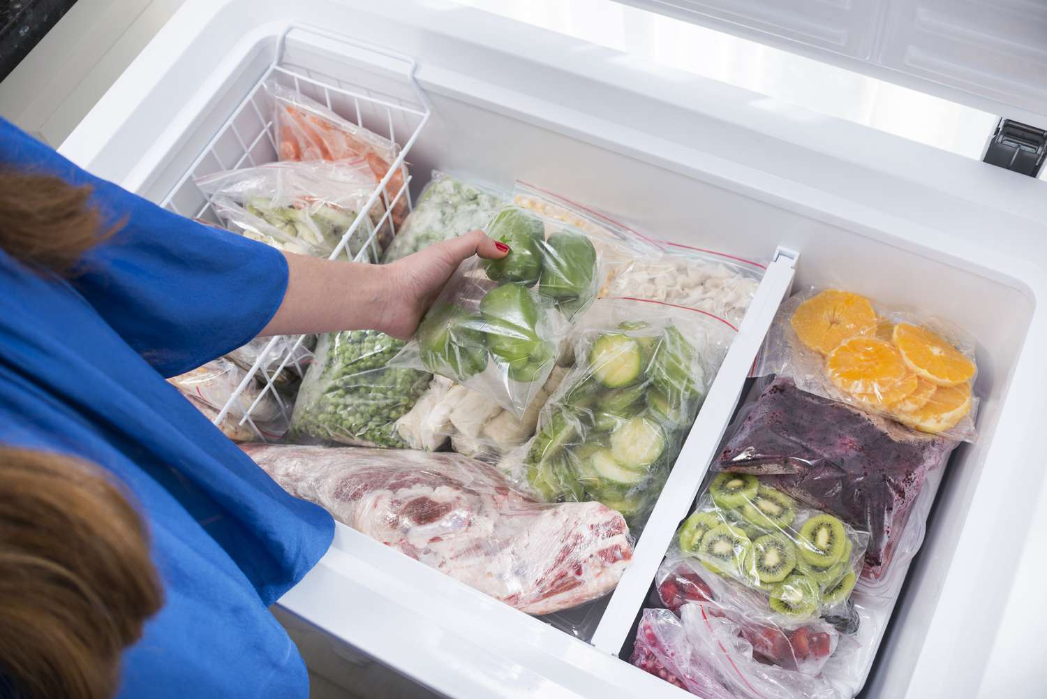 一个女人把蔬菜放进冰箱。
