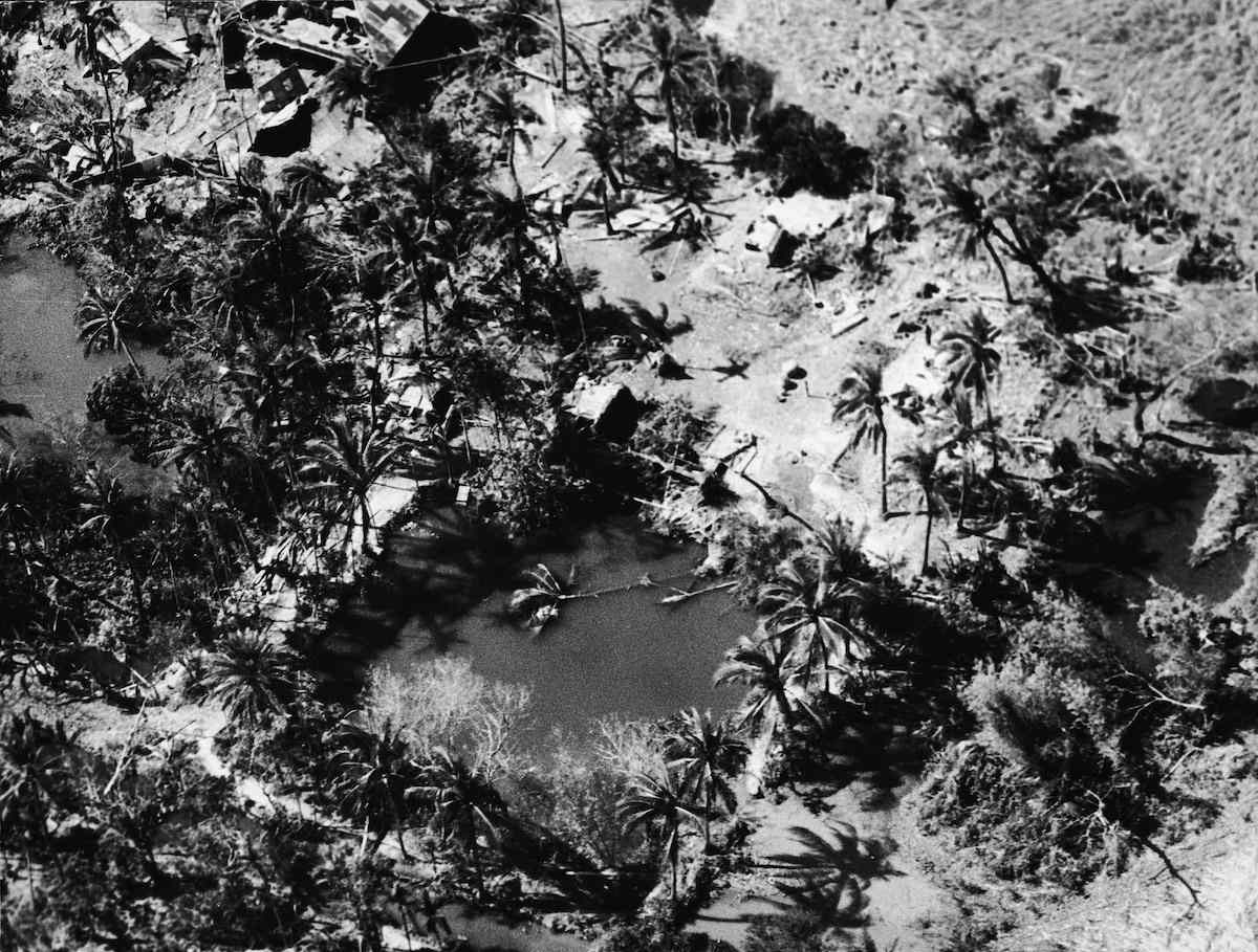 1970年11月13日袭击了该地区的热带气旋和潮汐浪潮破坏了博拉岛上一个村庄的鸟瞰图。“width=