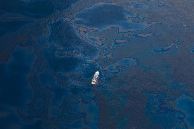 一艘船驶过由深水地平线石油泄漏造成的浮油