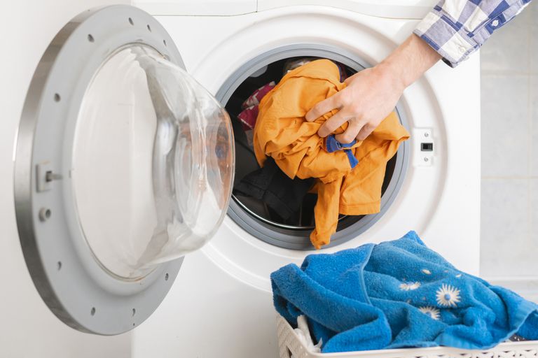 人手把脏衣服放在洗衣机里