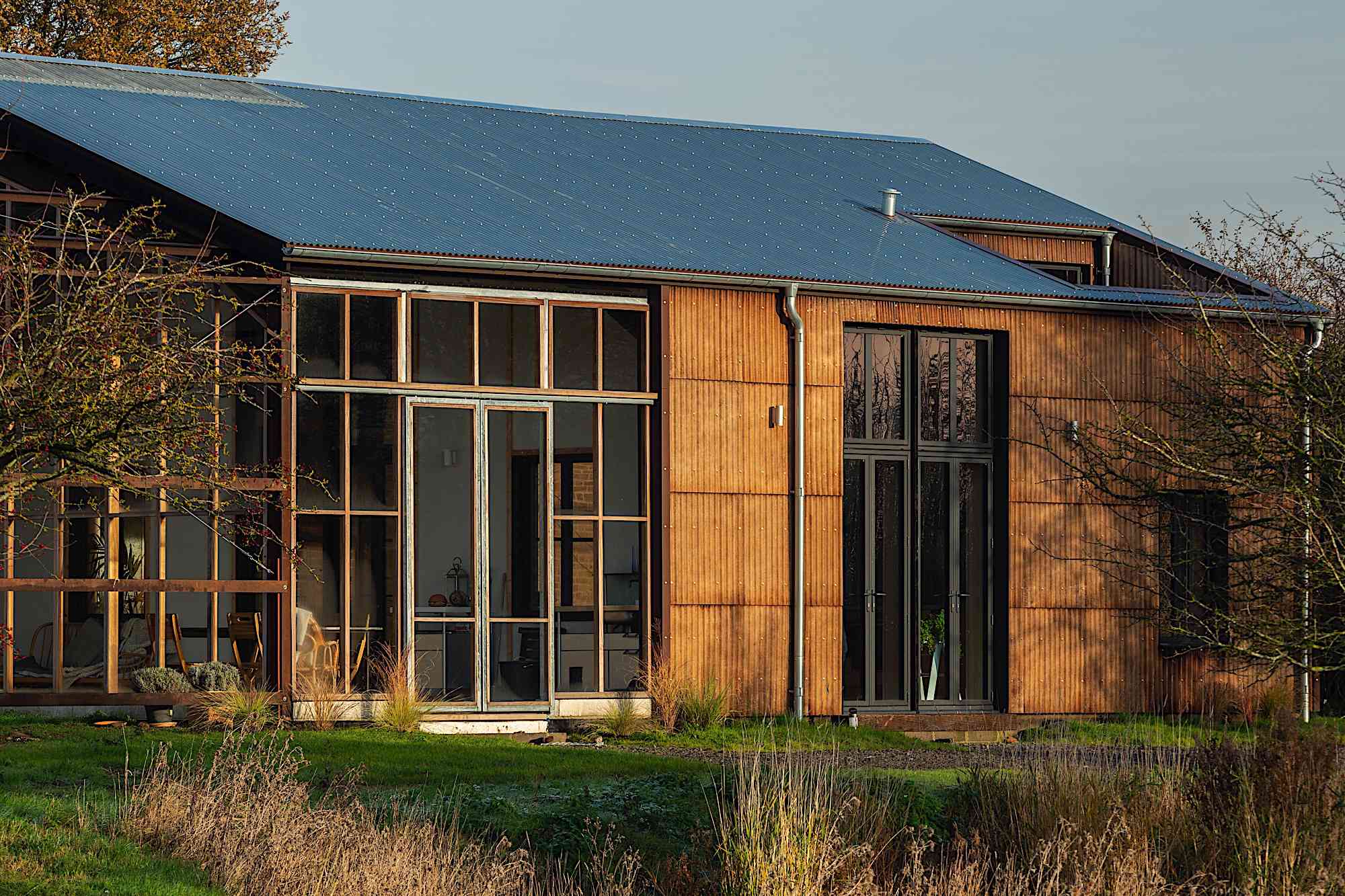 房子的外部，带窗户和太阳能屋顶。“width=