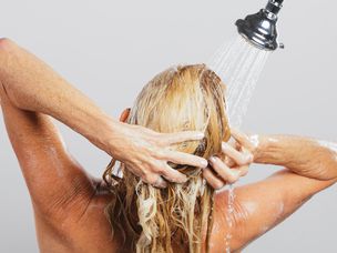 成熟的女人在淋浴时冲洗头发