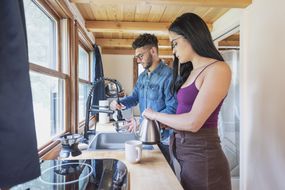 Two people in a tiny house kitchen