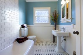 旧房子里的蓝色和白色浴室。“width=