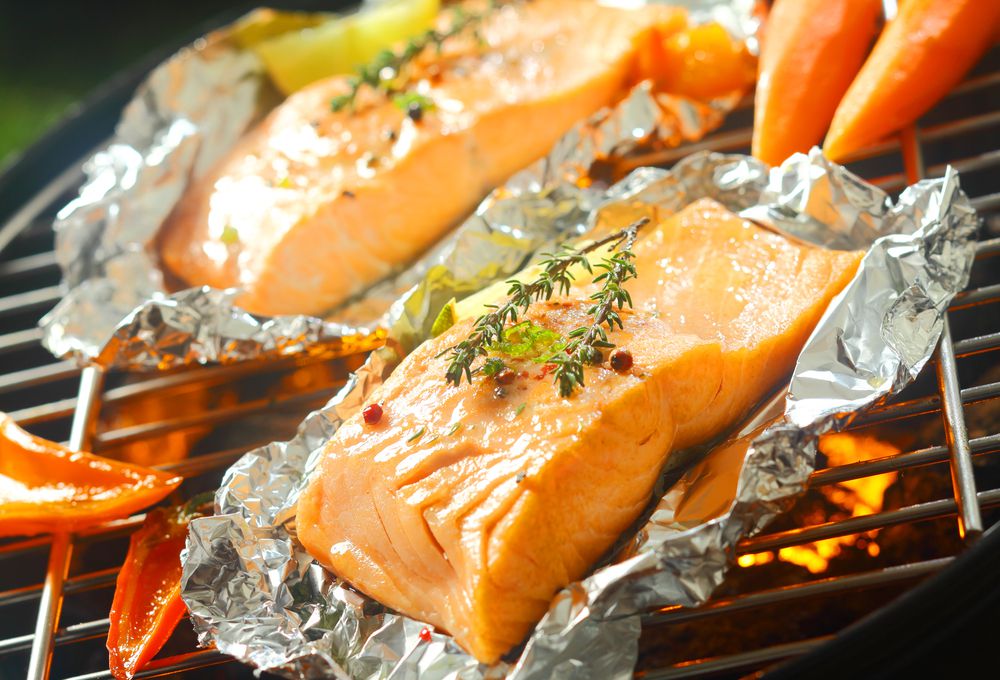 鲑鱼在铝箔中的烤架上煮熟
