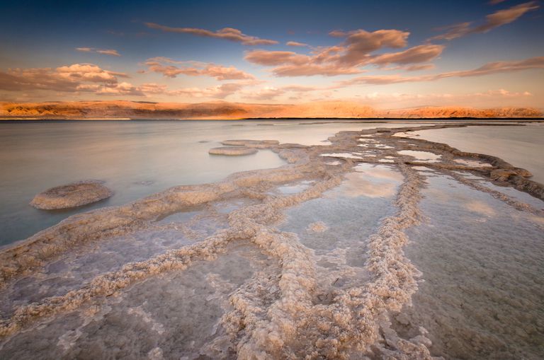 一览死海及其盐沉积的景色。“class=