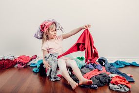 小女孩躺在一堆衣服里