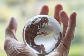 A human hand holding a globe