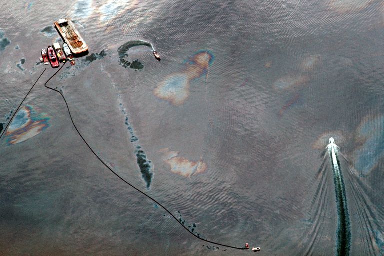 埃克森·瓦尔迪兹（Exxon Valdez）溢油后，小船掠过油覆盖的水的鸟瞰图“class=