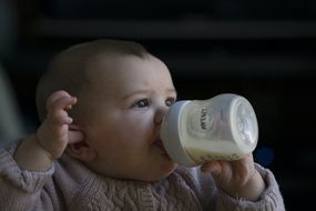 婴儿使用塑料喂养瓶“width=