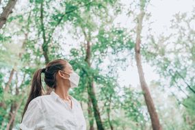 女人在森林大自然中远足戴着口罩