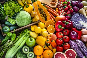 彩虹分布的水果和蔬菜包括西红柿，紫甘蓝，橙子，柠檬，芹菜等