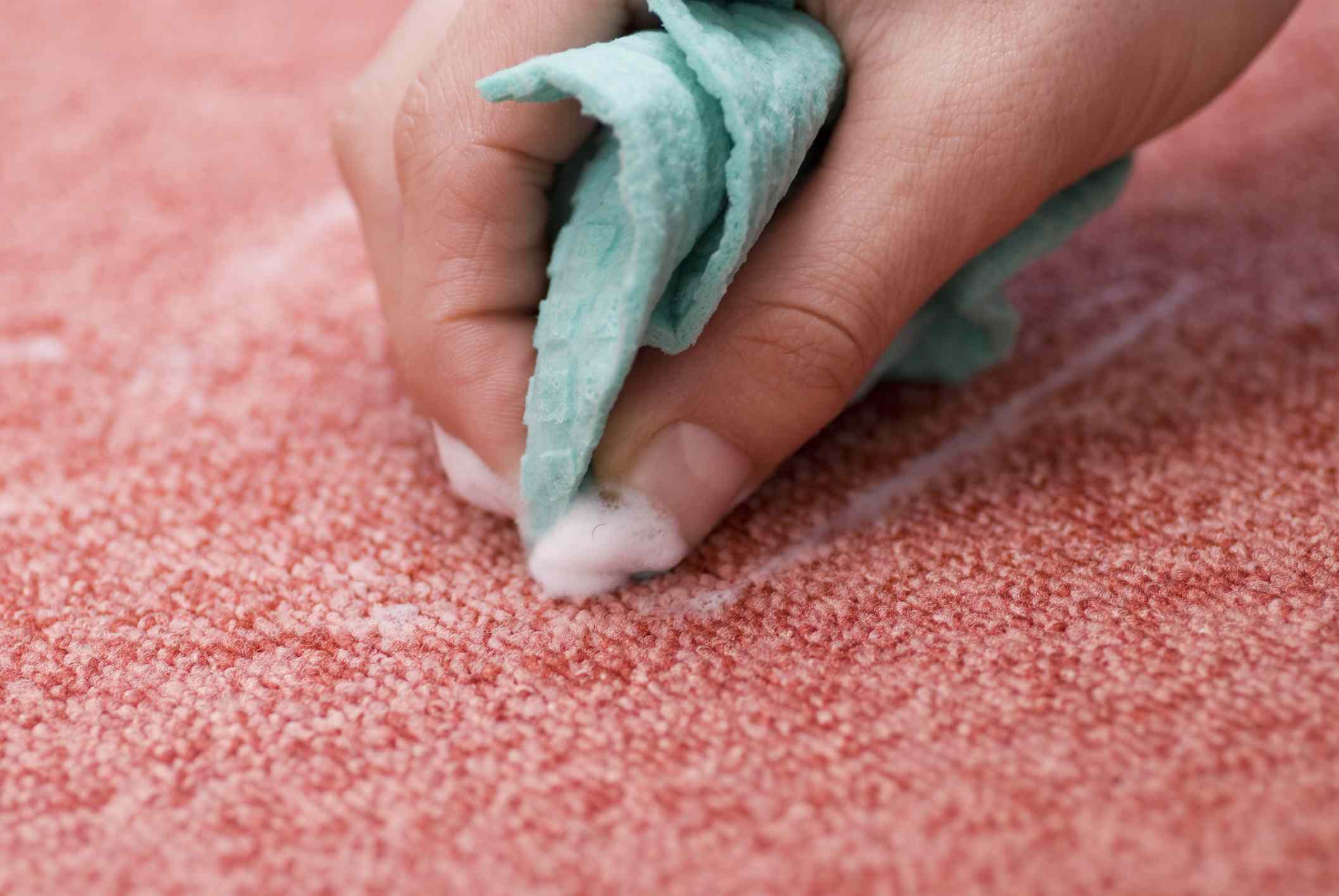 用一块布手洗粉红色的地毯