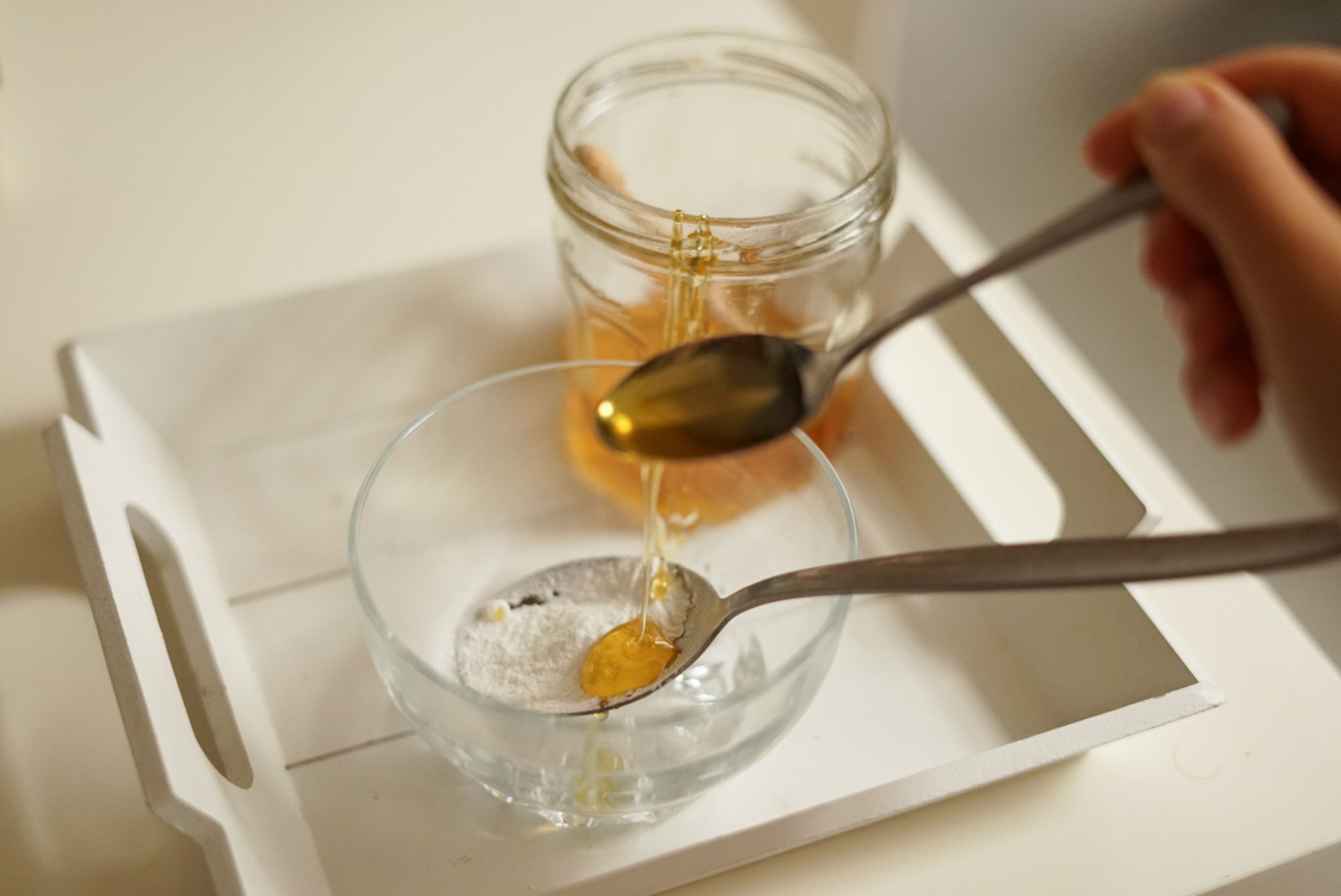 蜂蜜从一把勺子里淋上了玻璃瓶罐的天然剥离苏打水