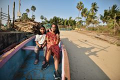 两个年轻女孩坐在渔船上