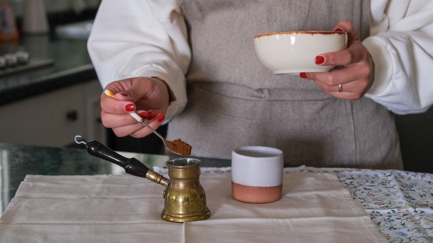 半身镜头的人准备土耳其咖啡与陶瓷杯和黄铜土耳其咖啡壶