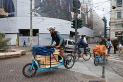 两个周期快递员在提供食物时骑着货物自行车。