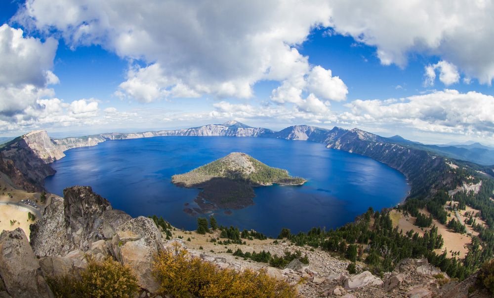 一个清澈的，蓝色的湖和一个被山和树环绕的岛屿