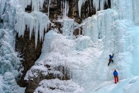 Johnston Creek的冷冻底部瀑布上的冰登山者