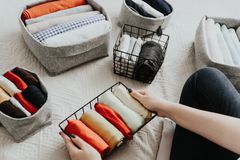 叠衣服，整理箱子和篮子里的东西。整洁的概念，极简的生活方式和日式t恤折叠系统。