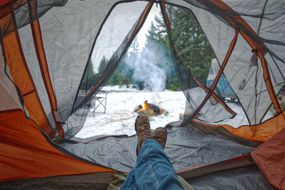 里面的人露营帐篷在冬天与火和雪
