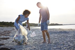 两个人在海滩上收集垃圾