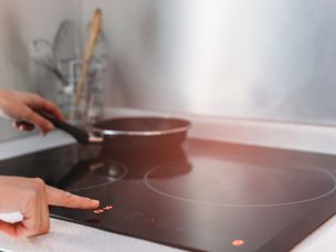 女性的手在厨房使用感应炉的细节