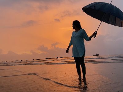 女人站在海滩伞在孟买