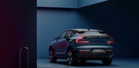 在昏暗的空间里，一辆2022年沃尔沃C40充电电动SUV的图片，插入电源。