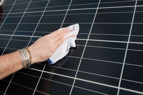 一个清洗光伏太阳能电池板的男人的特写。