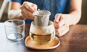 用泡茶器在一个透明的杯子里泡茶