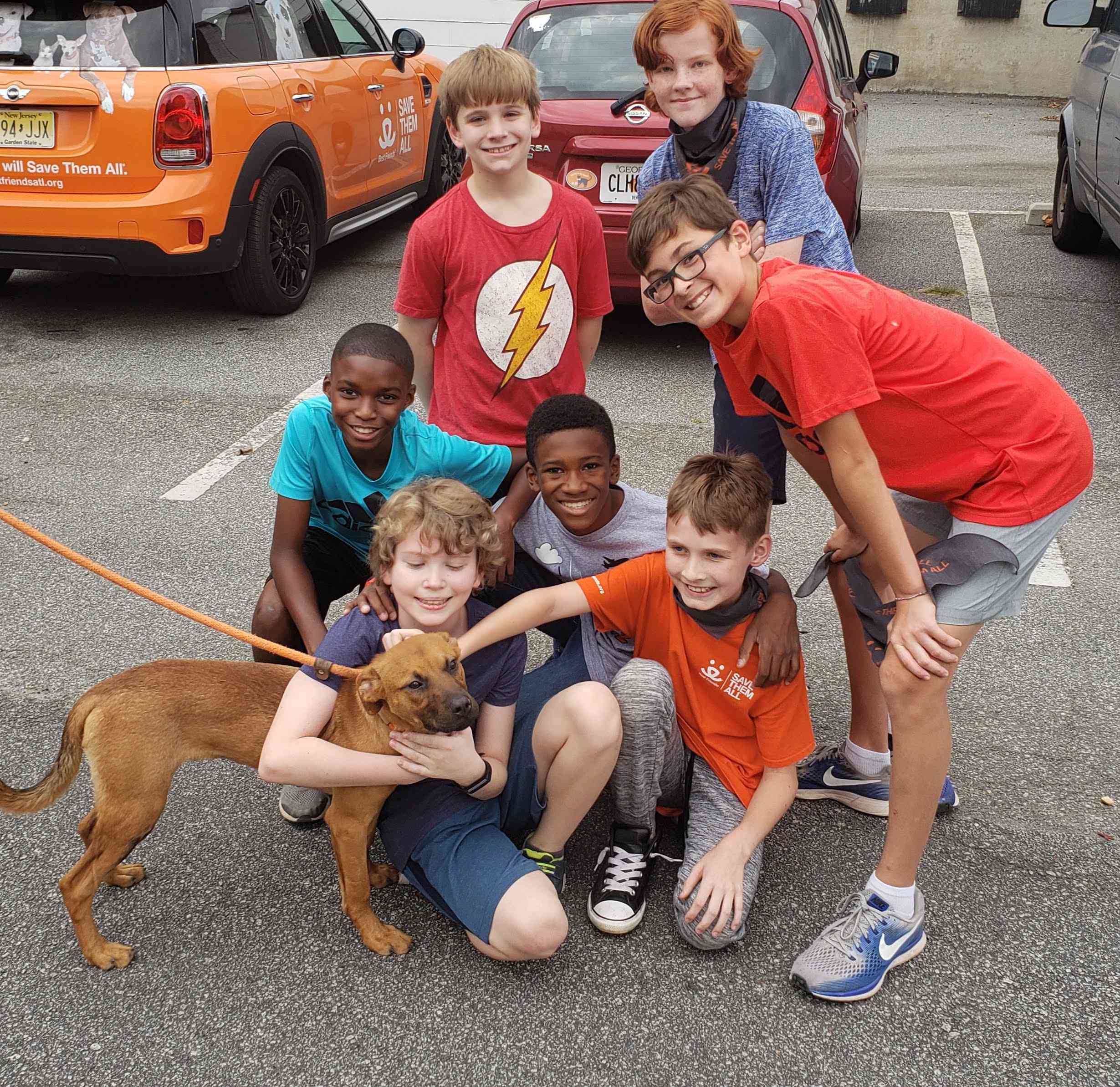 杰克和他的朋友们拥抱着“好朋友”收容所的一只狗。