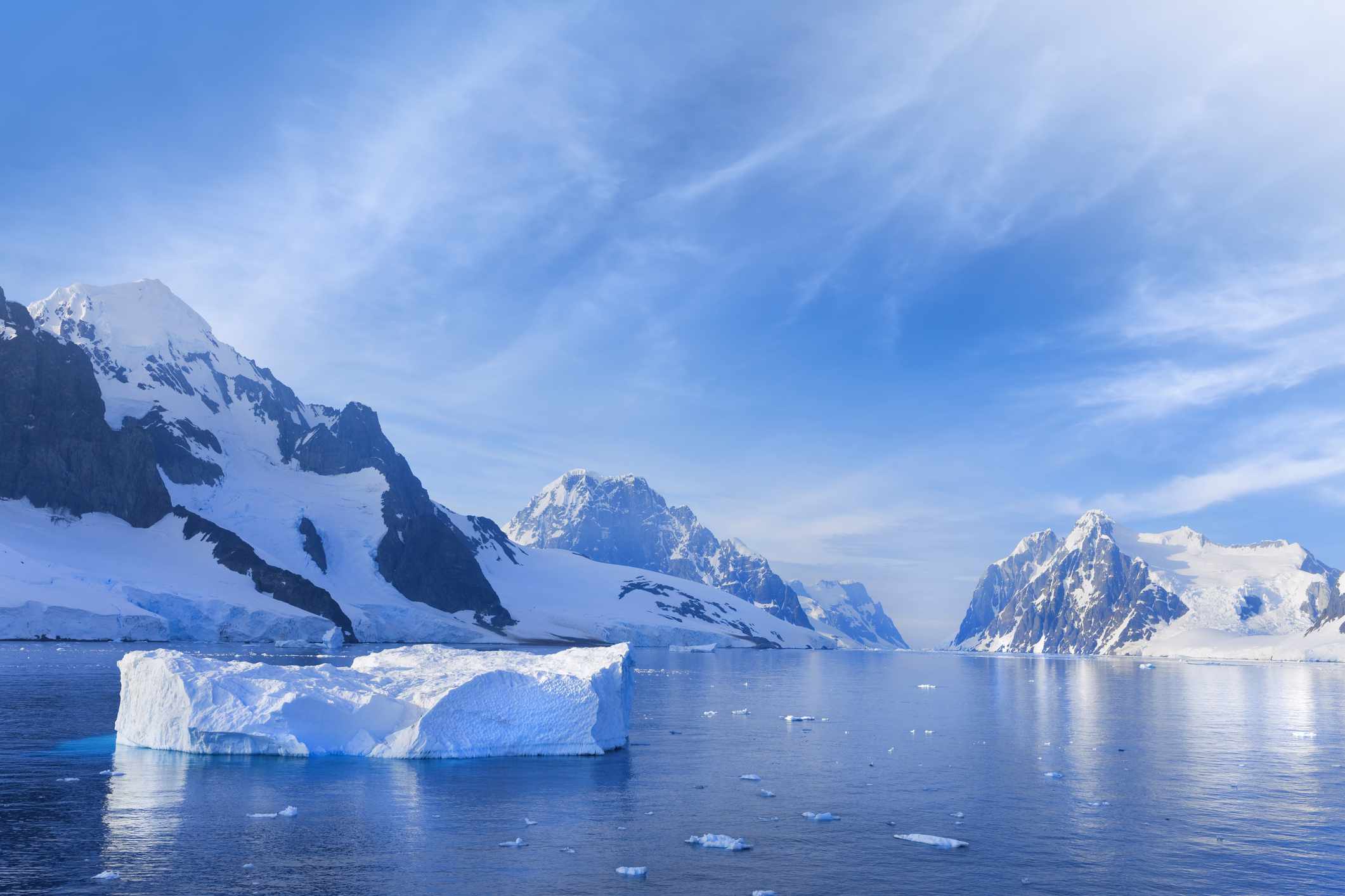 冰冷的山脉环绕着平静的蓝色水域，周围有小冰川