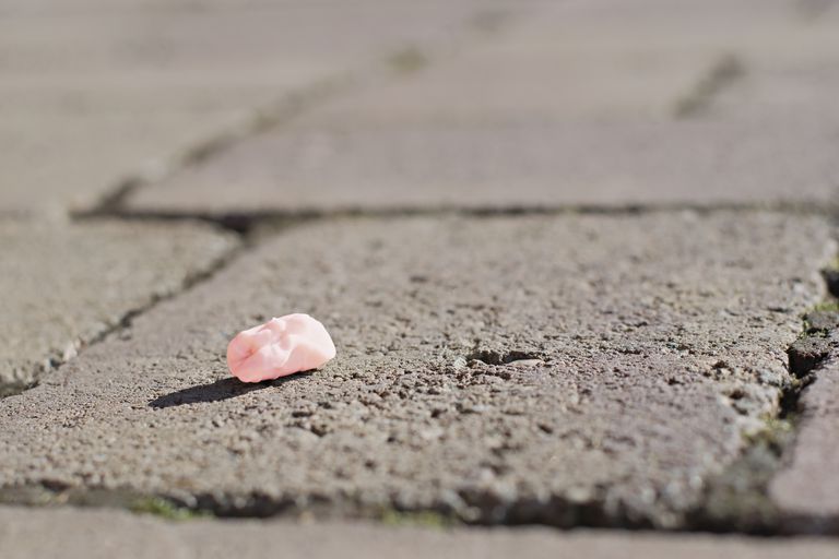 粉红色用过的口香糖吐在了人行道上＂class=