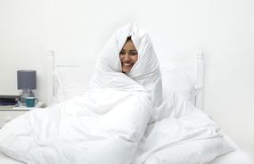 女人用白色的床罩包裹