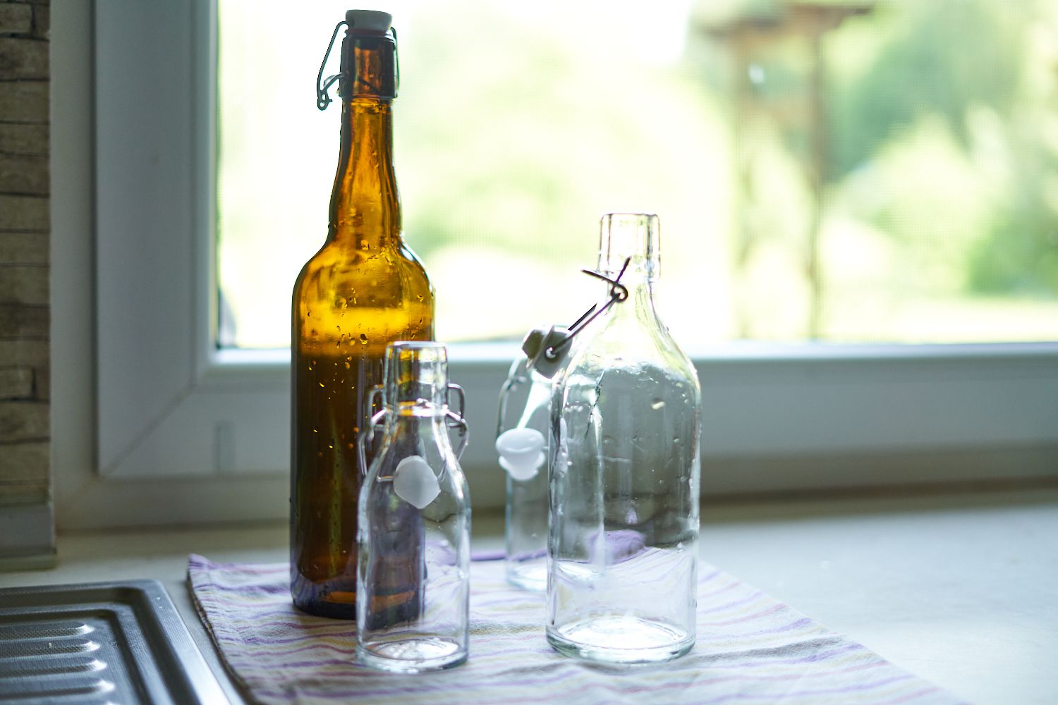 最近在厨房水槽旁边清洁的各种尺寸的玻璃翻转瓶