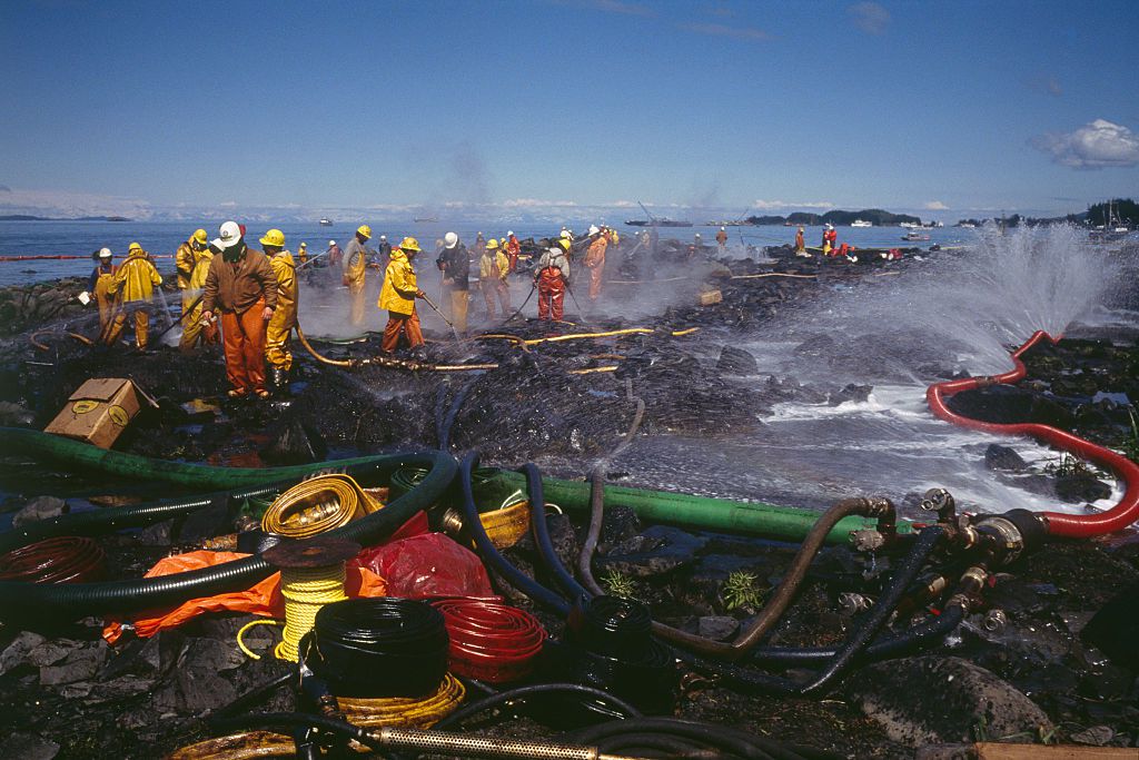 在埃克森·瓦尔迪兹号油轮泄漏后，一队身穿防护装备的消防队员正在清理油黑的阿拉斯加海岸。